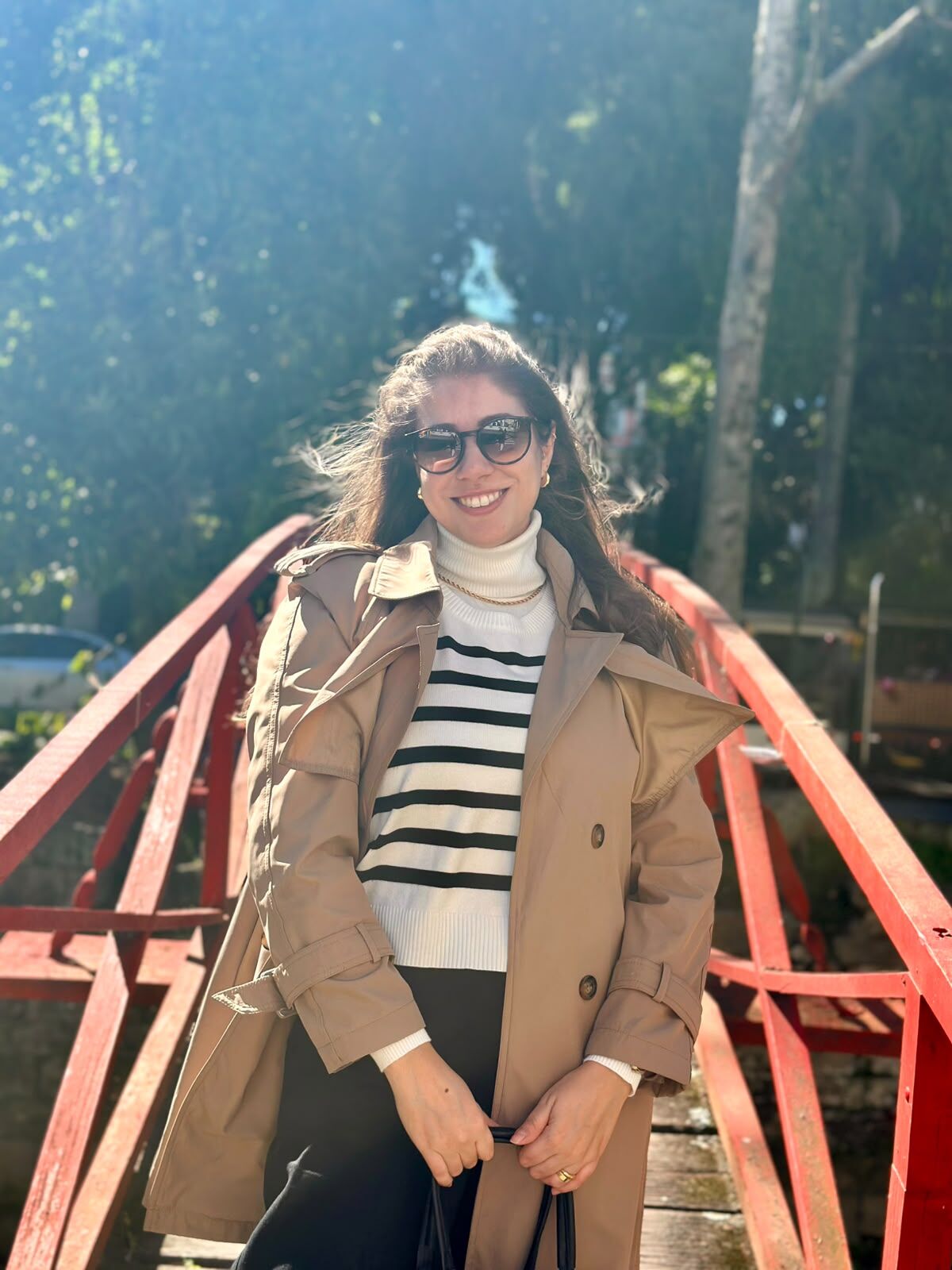 Carol diante de uma ponte vermelha em Petrópolis