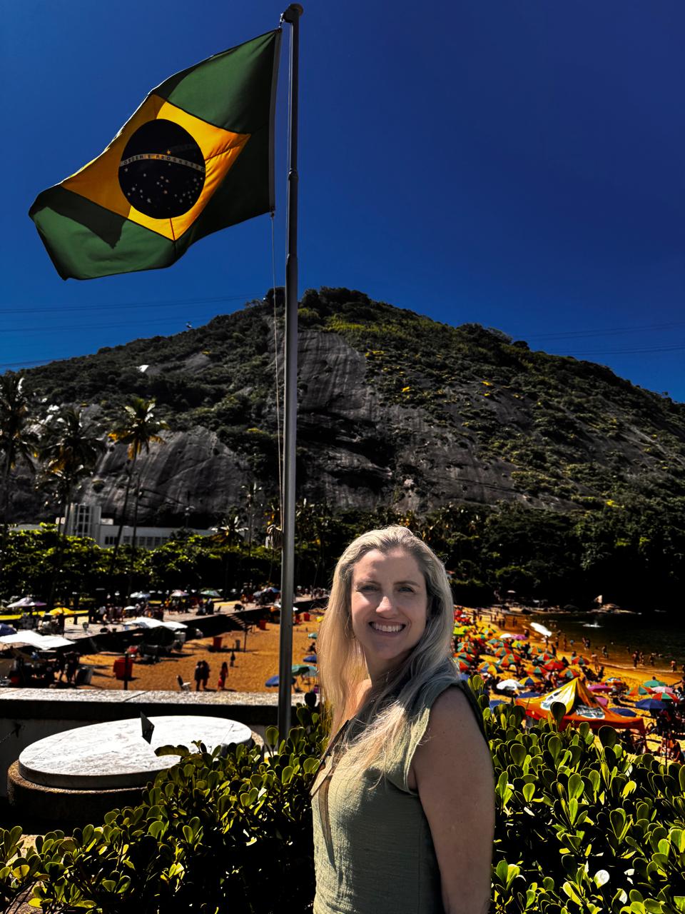 Andrea diante da bandeira do Brasil no Rio de Janeiro